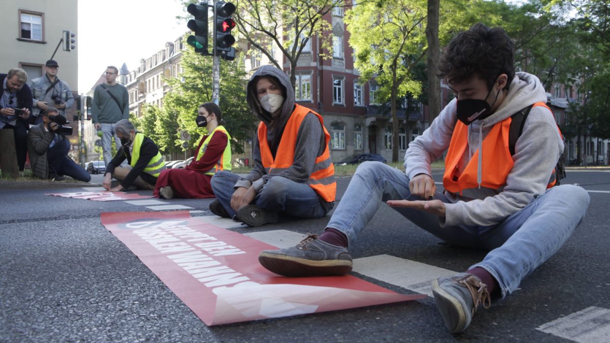 Aktivisten kleben sich mit Sekundenkleber an der Straße fest. - Foto: Letzte Generation