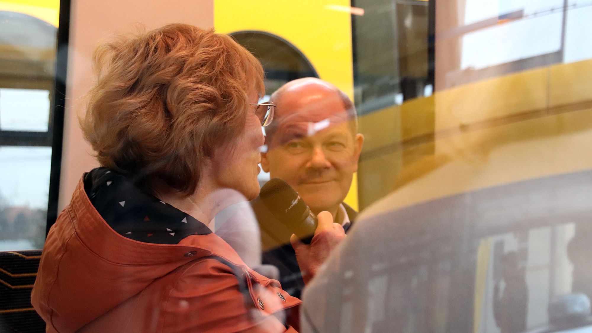 Eine Bürgerin mit Kanzler Scholz im Gespräch in der Straßenbahn. Foto: J. Frintert