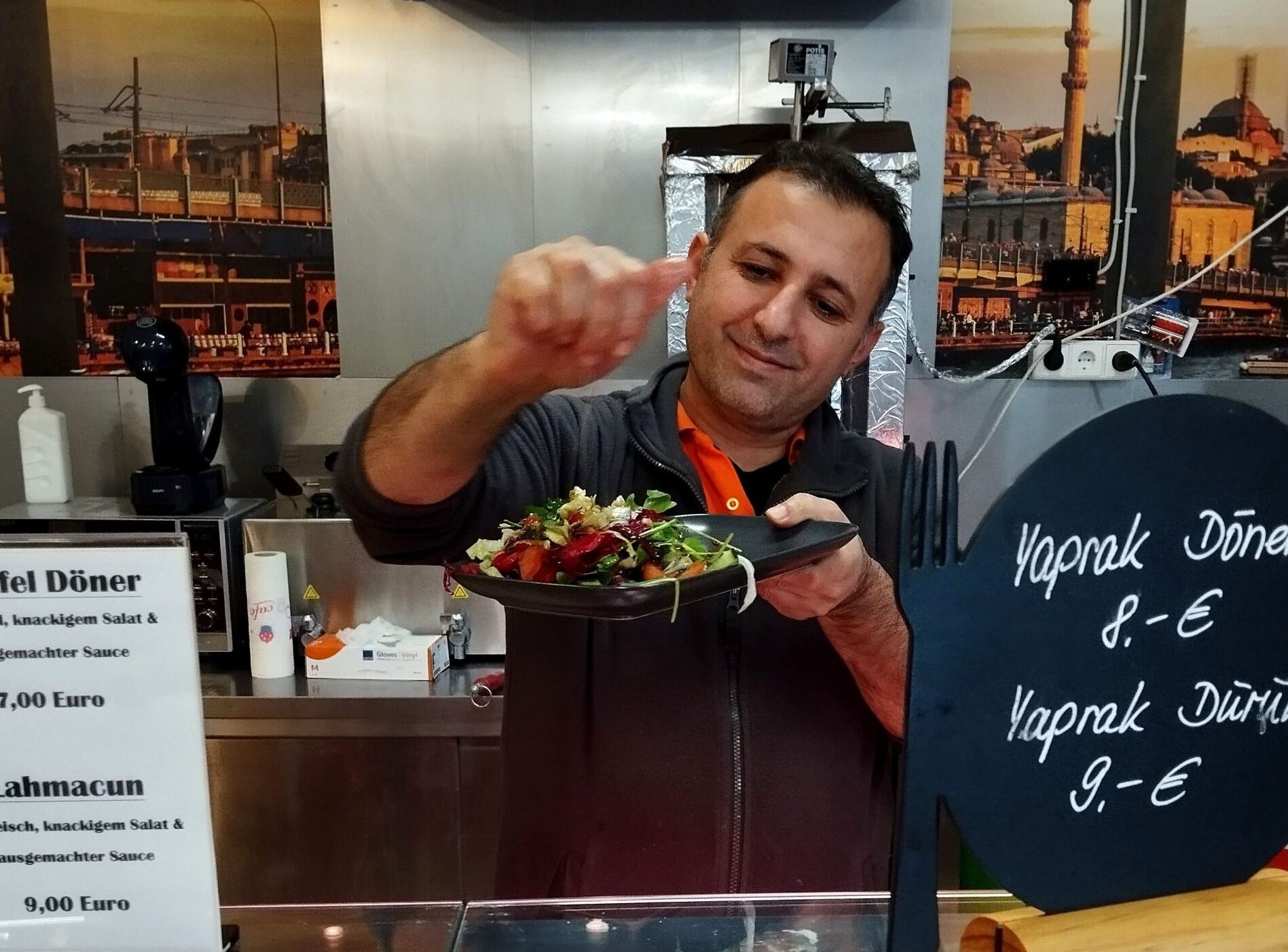 Aziz Tekce, wie er Zitronensaft auf den frischen Salat tropft.