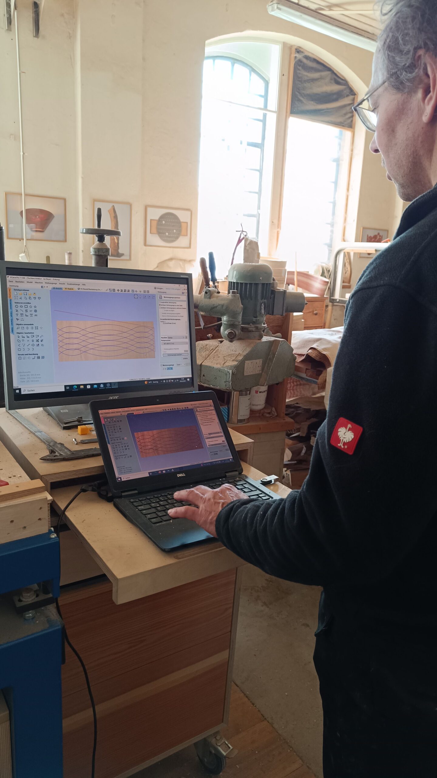 Beyer zeigt stolz eine CNC-Fräsmaschine. Für ihn bedeutet sie genaue und für die Hände sichere Holzbearbeitung.