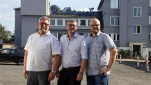 Restaurierter Barock-Schriftzug leuchtet wieder in Dresden-Kaditz Die Chefs des Barock-Eventparks, Torsten Meisel (links) und Benjamin Venter (rechts), in der Mitte Matthias Kuhnt vom Tintenhersteller Octopus Fluids. Foto: J. Frintert